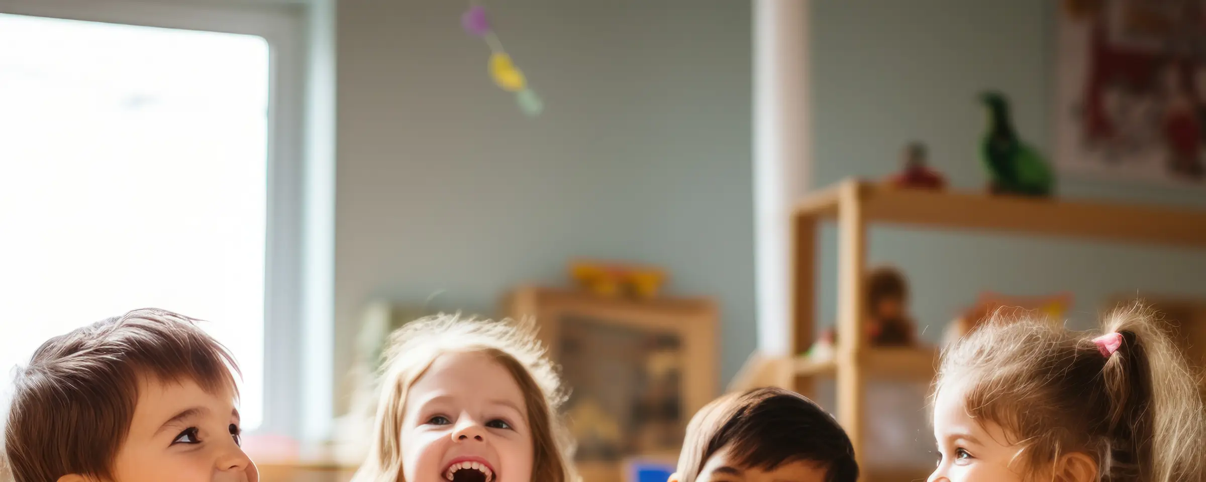 Children laughing around a tower of wooden blocks in a classroom
