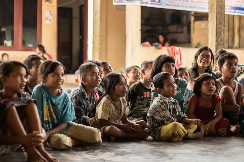 A large group of children sitting together on the floor