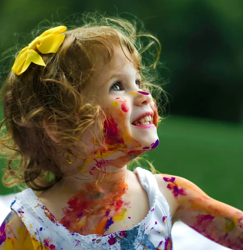 A laughing girl with paint on her face