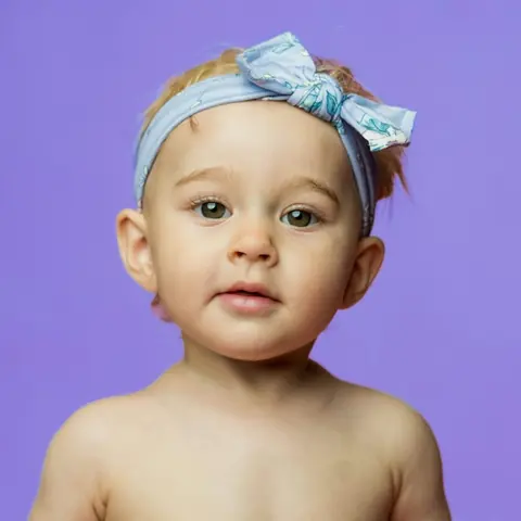 A baby wearing a blue bow headband