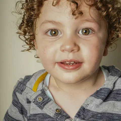 A smiling boy with curly hair